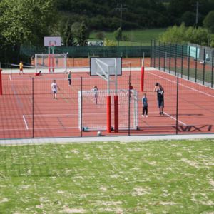 Man sieht einen Platz mit Basketballkörben und Menschen