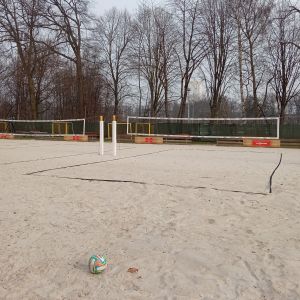 Man sieht ein Sandfeld mit einem Netz zum Beachvolleyball spielen