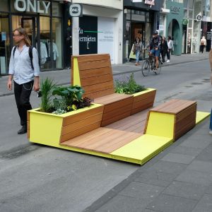 Sitzmöglichkeit aus Holz mit Begrünung auf der Ehrenstraße