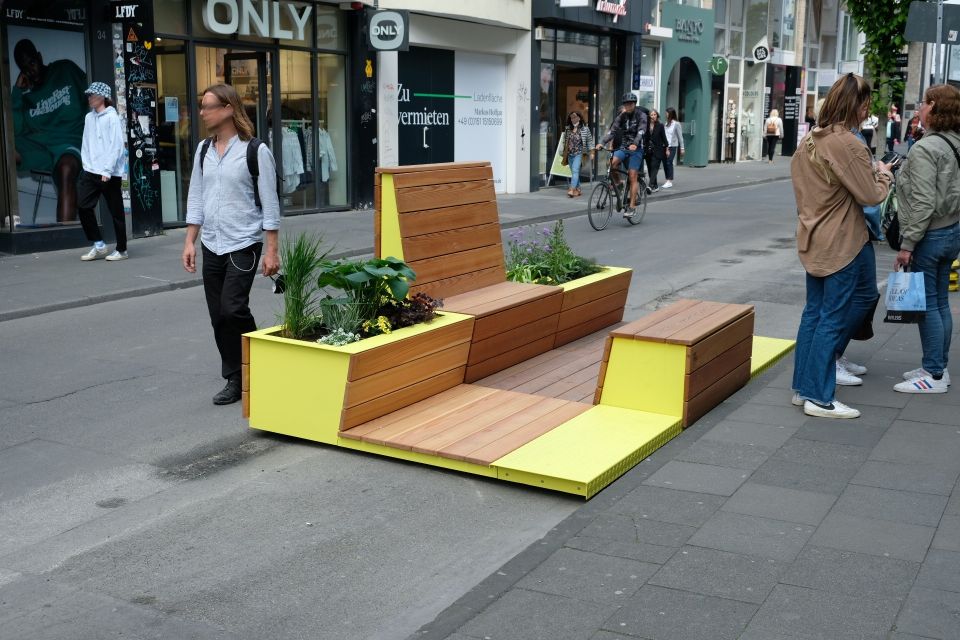 Sitzmöglichkeit aus Holz mit Begrünung auf der Ehrenstraße