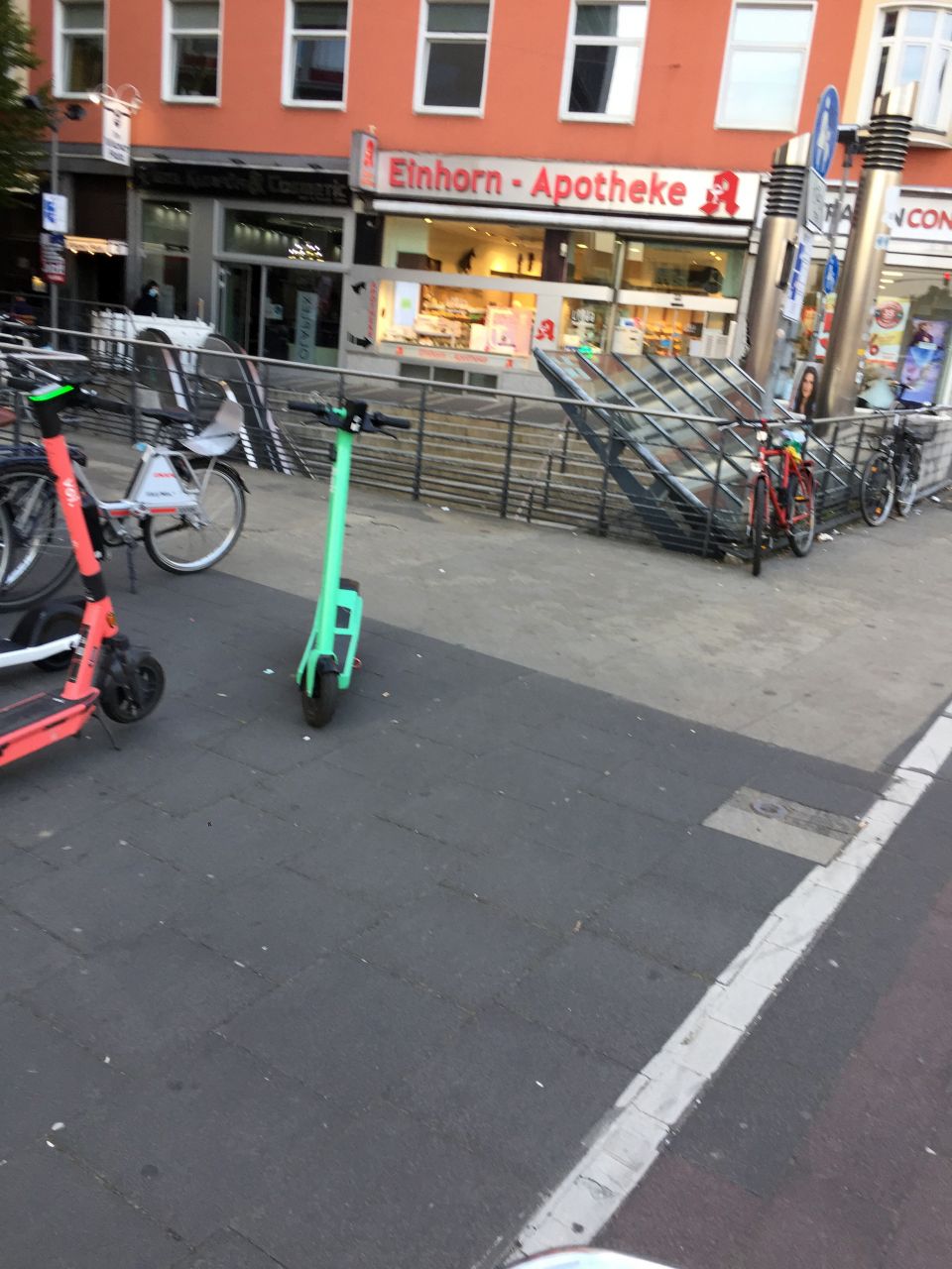 Gepflasteter Platz vor der Einhorn-Apotheke. Auf dem Platz stehen Elektro-Roller und Fahrräder.