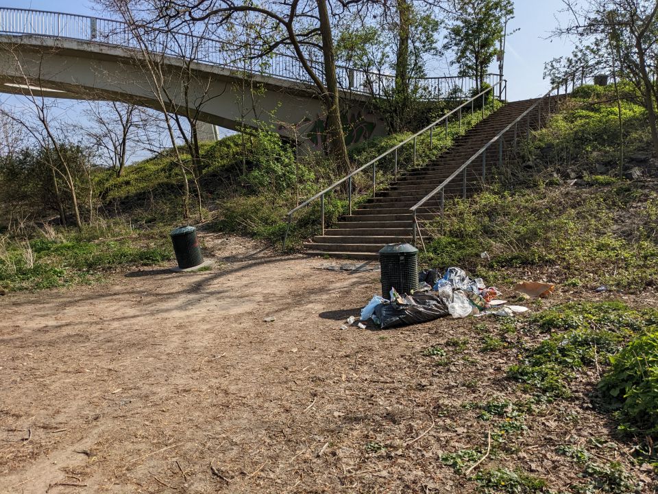 Blick auf vollen Mülleimer vor der Treppe auf der Jugendparkinsel