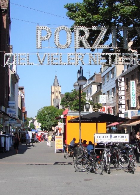 Blick über die Bahnhofstraße mit Schriftzug Porz - Ziel vieler netter Leute