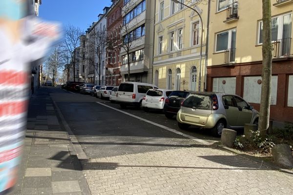 Zu sehen ist der Bereich Thumbstraße zwischen Diesel- und Eythstraße. Links ist ein Bürgersteig. Rechts parken Autos in Parktaschen.