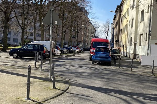 Zu sehen ist der Bereich Höfestraße/Markt zwischen Thumb- und Bertramstraße. Links parken Autos in Parktaschen. Rechts parken Autos vor einem Wohngebäude. Es gibt Bürgersteige auf beiden Seiten.