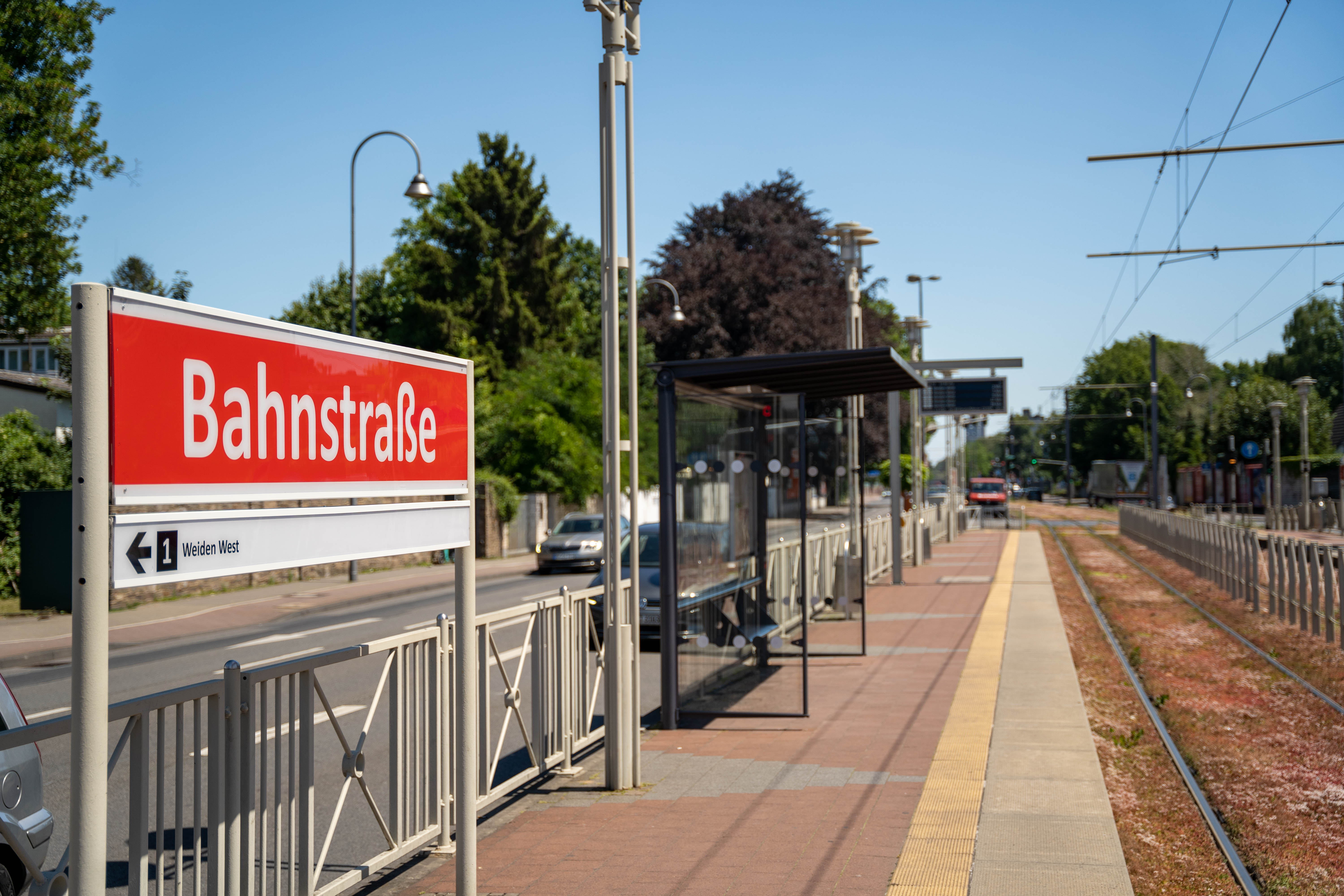 Seitlicher Blick vom Bahnsteig auf das Haltestellenschild Weiden Zentrum Richtung Weiden West