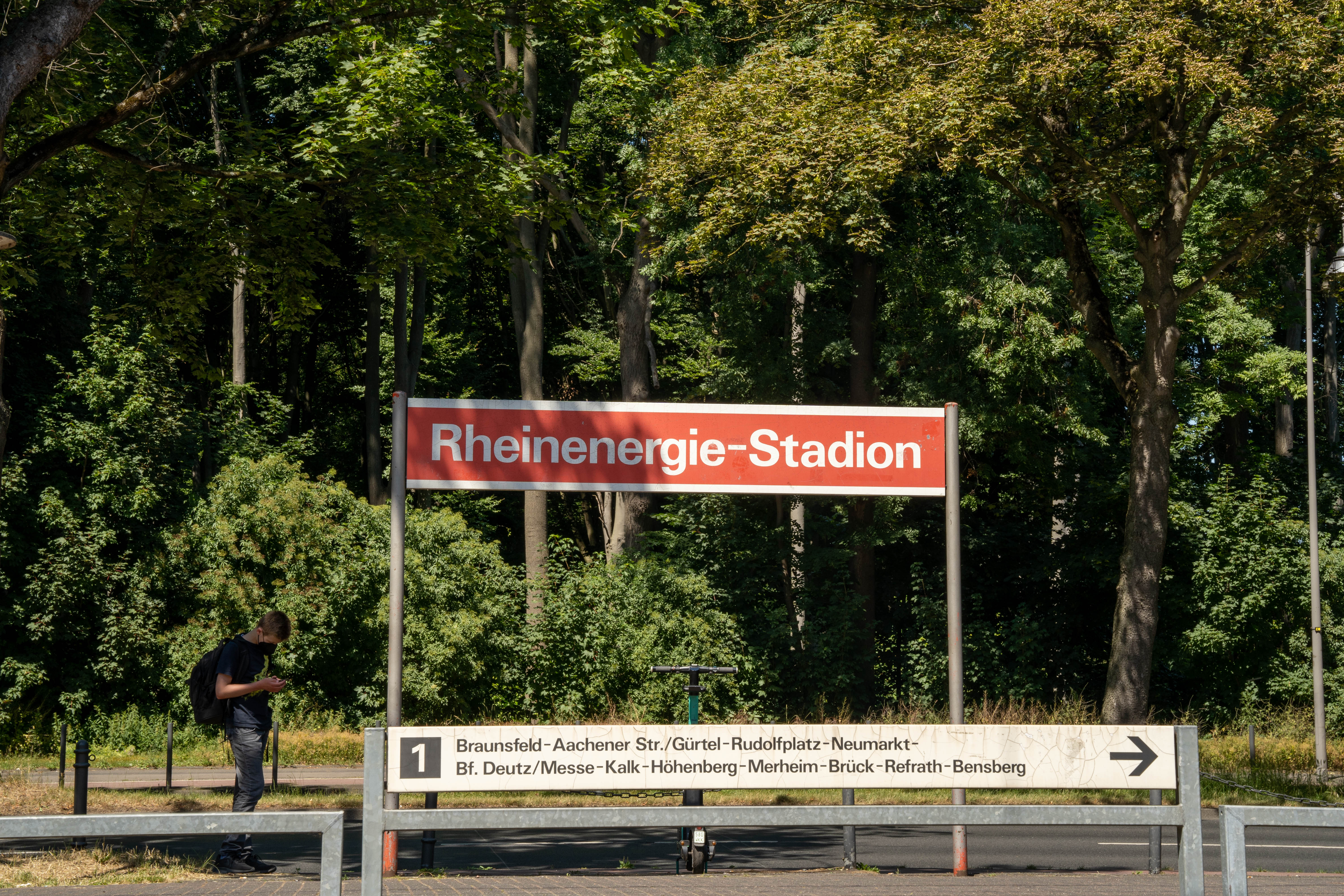 Blick von der gegenüberliegenden Seite auf das Haltestellenschild Rheinenergie-Stadion