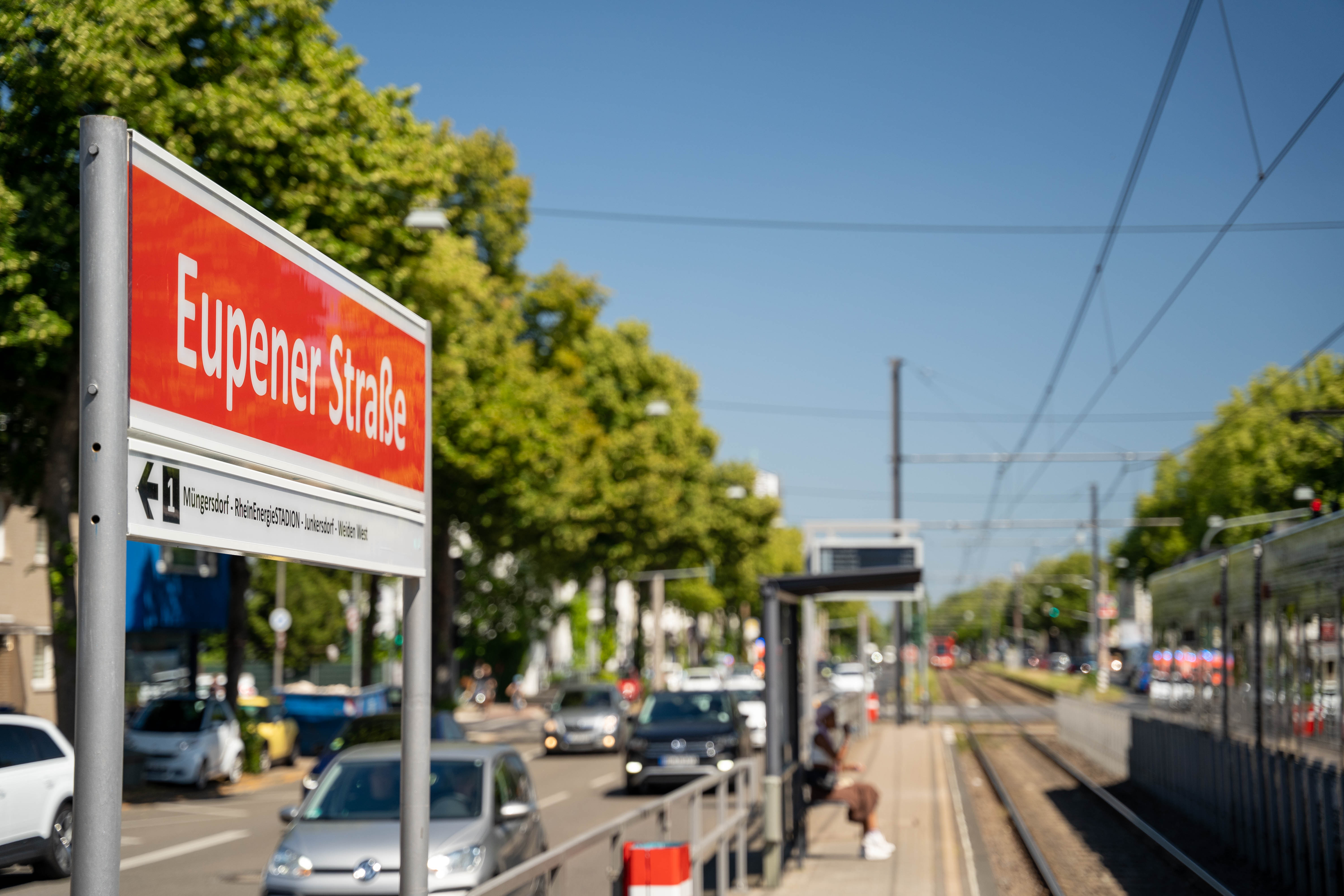 Seitlicher Blick vom Bahnsteig auf das Haltestellenschild Eupener Straße