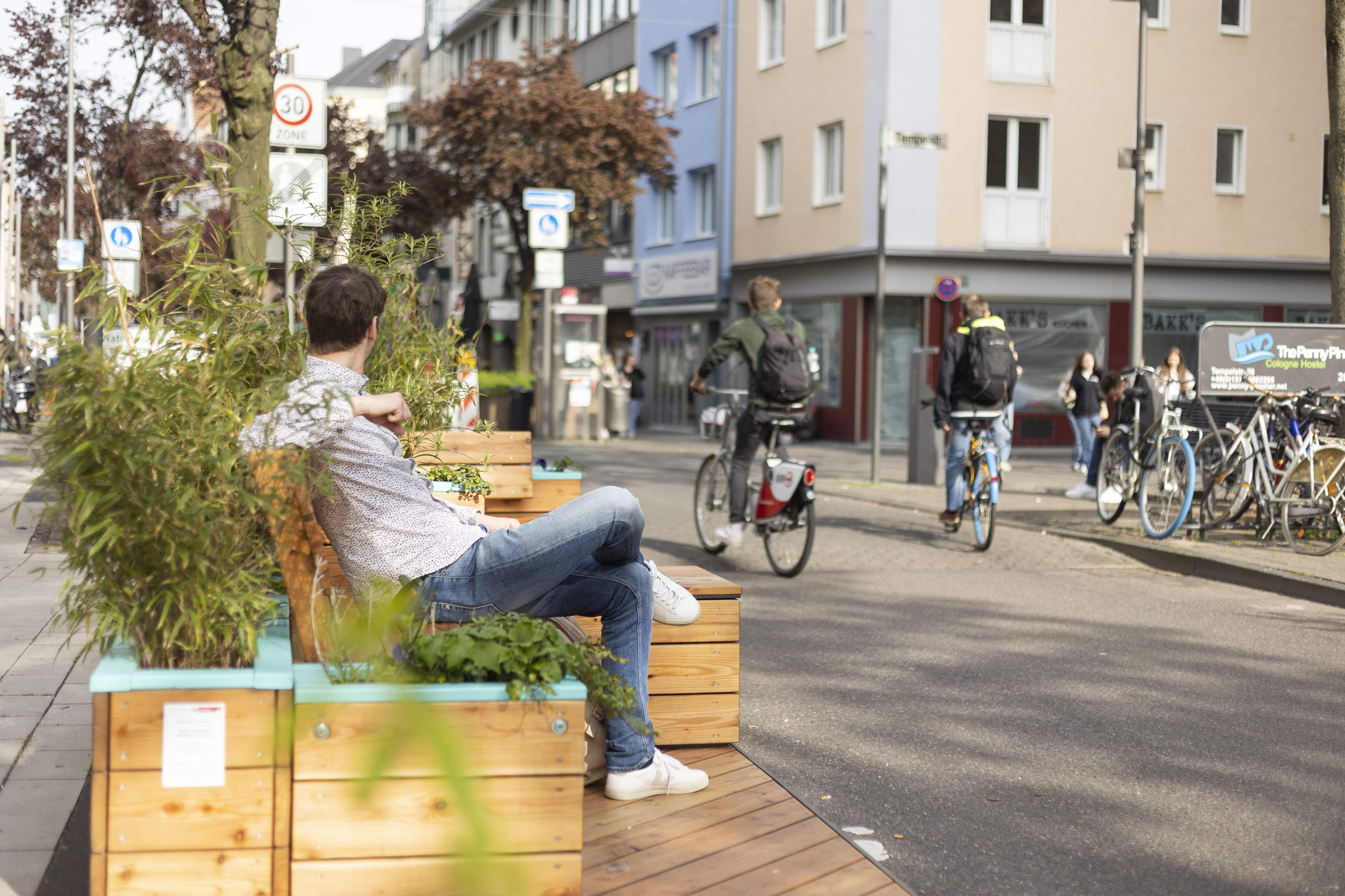 Blick auf Deutzer Freiheit Mann sitzt auf Stadtmobilar