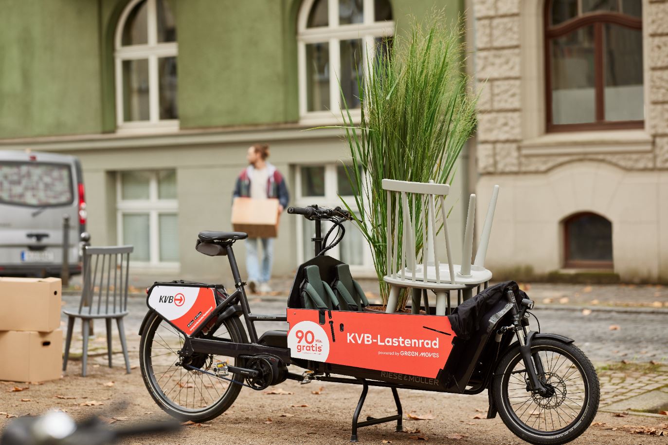 KVB Lastenrad steht auf einer Straße vor zwei Häusern.