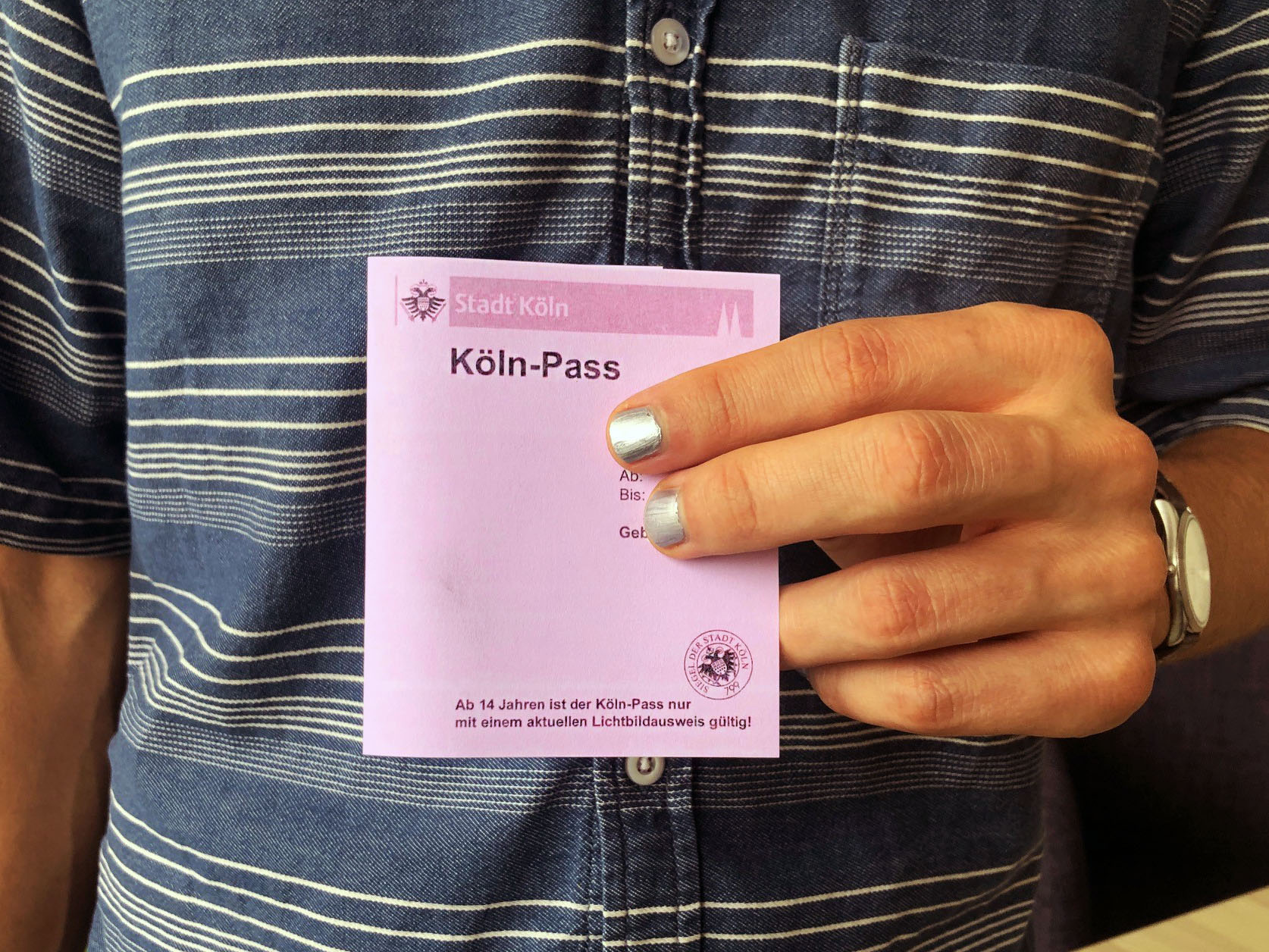 Mensch hält Köln-Pass in der Hand