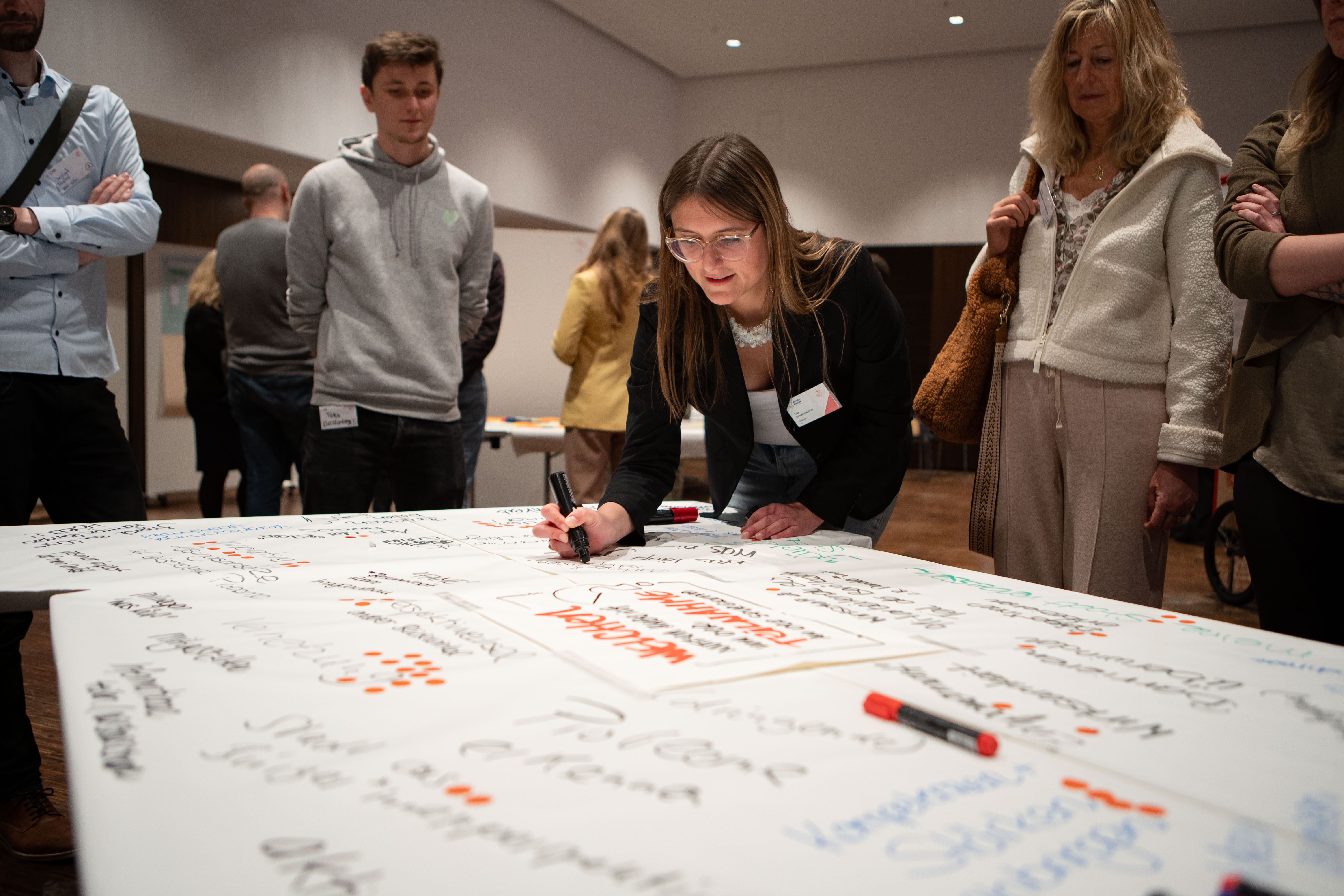 World Cafe - Menschen schreiben auf großem Papier