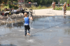Kleines Kind läuft durch Wasserfontäne